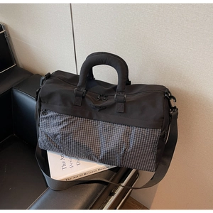 Detail of checkered travel bag with padded handles and adjustable shoulder strap