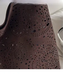 Detailed view of dark brown laser-cut hollow pattern on lightweight tote bag material