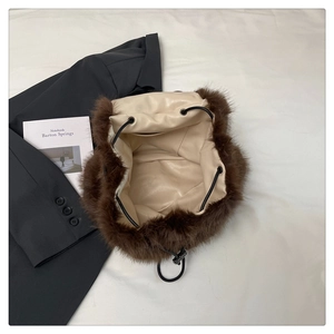 Detail of soft brown faux fur backpack with black drawstring and spacious interior