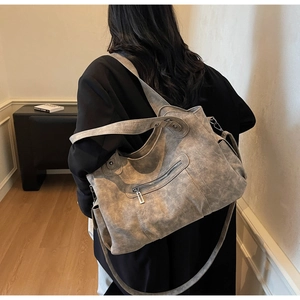 Detail showing the gray vintage tote bag with wide strap and decorative zipper pocket