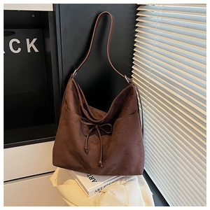 Detail of vintage brown suede hobo bag with bow tie and large tote capacity