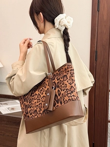 Vintage leopard print large tote bag with dark brown leather straps shown on shoulder