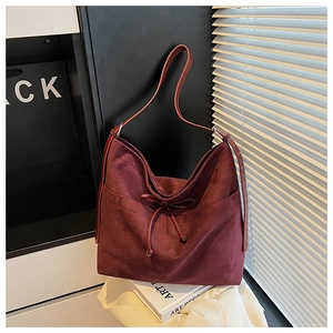 Detail view of burgundy frosted suede hobo tote bag featuring drawstring bow decoration