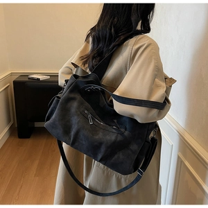 Detail showing matte leather texture and metal zipper pocket of this vintage tote bag