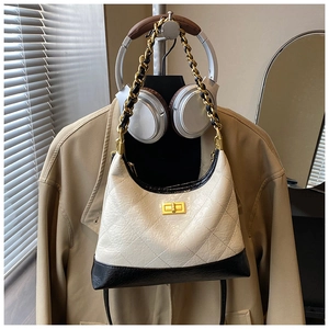 Détail du sac en cuir matelassé noir et blanc avec chaîne dorée et fermoir métallique