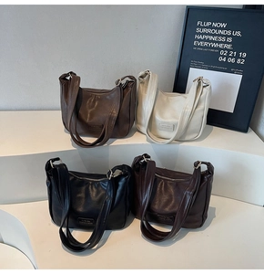 Detail view of four semi-moon dumpling bags in dark brown, cream, black, and dark red colors