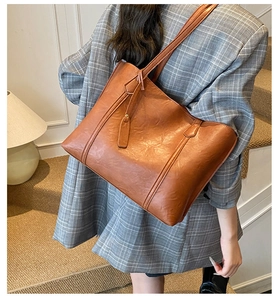 Close-up of brown faux leather tote bag with vintage texture and stylish shoulder strap