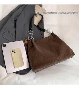 Leopard print tote bag size comparison with phone and iPad for capacity visualization