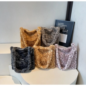 Detailed close-up of plush tote bags in multiple leopard and tiger patterns on white display