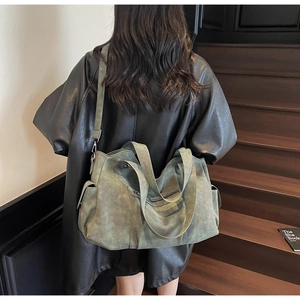 Detail view of large vintage matte olive green tote bag worn over the shoulder