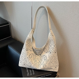 Close-up of white laser-cut geometric hollow pattern on the large hobo shoulder bag
