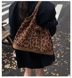 Détail du sac cabas léopard vintage avec lanières en cuir marron et nœud décoratif