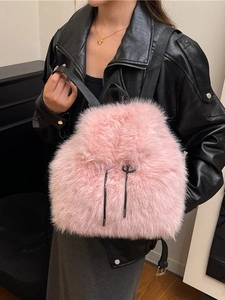 Stylish pink faux fur backpack with black drawstring and adjustable straps for women