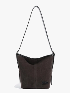 Sac seau rétro en daim marron avec garniture en cuir et bandoulière sur fond blanc