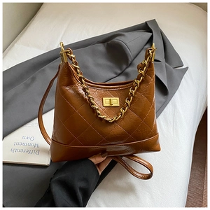 Détail du sac hobo en cuir matelassé marron avec chaîne dorée et texture vintage