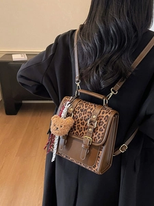 Retro leopard print backpack with brown color blocking and bear charm worn by a model