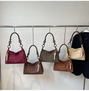 Detail of five stylish faux suede crescent bags featuring wooden bead handles and tassel charms