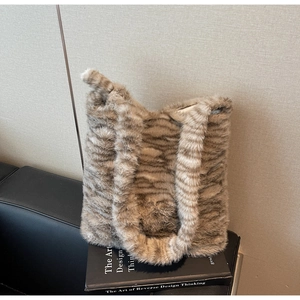 Detailed macro shot of the fluffy faux fur texture and brown tiger stripes on this tote bag