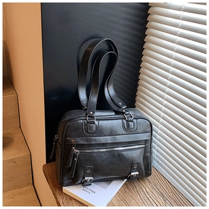 Detail view of black vintage tote bag featuring a front zipper pocket and strap accents