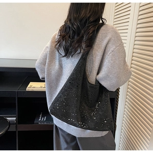 Detailed view of black laser-cut hollow tote bag with starry texture on shoulder