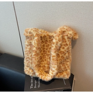 Detail shot of plush leopard print tote bag fabric and soft faux fur handle texture