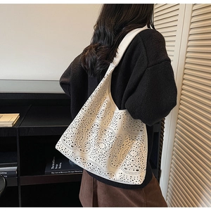 Detailed view of white laser-cut hollow pattern on a large vintage tote bag