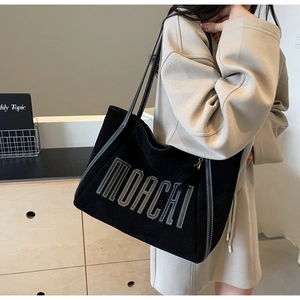 Close-up of black suede tote bag with white MORCHI lettering and contrast stitching