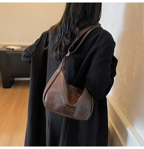 Detail showing high-quality brown hobo bag leather texture and Mo Ren embossed logo
