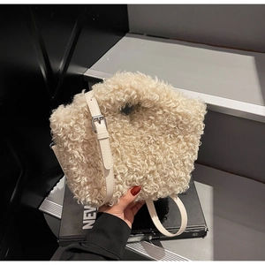 Close-up of beige plush crossbody bag with adjustable strap on a minimalist background
