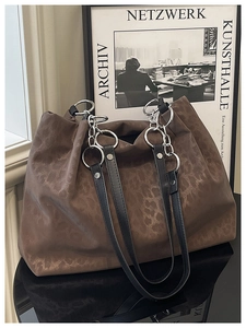 Detail of dark brown leopard print tote bag with silver chain and leather handle