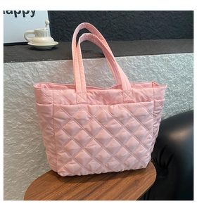 Detail of pink quilted nylon tote bag featuring classic diamond stitching on wooden tray