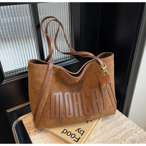 Brown matte tote bag detail with MOACHI lettering and a cute elephant leather charm