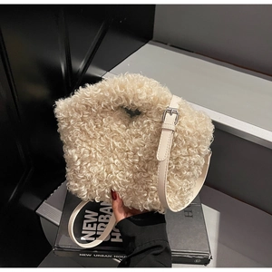 Close-up of plush faux fur handbag with adjustable leather strap and top cutout handle