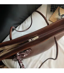 Detail of silver zipper and brown leather tote bag with printed silk scarf accent