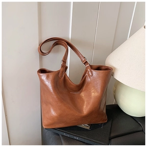 Close-up of vintage brown PU leather tote bag with subtle grain and brand logo