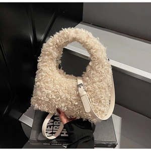 Detailed macro of cream faux sheepskin texture and sleek leather strap on a teddy bag