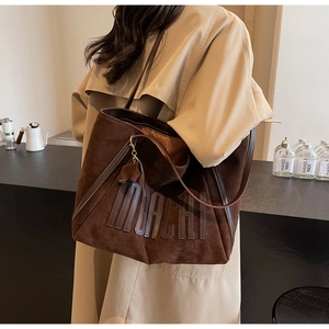 Detail shot of a large brown suede tote bag with MARCHI logo leather patch decoration