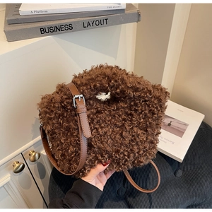 Close-up of fluffy dark brown faux shearling texture with leather adjustable shoulder strap
