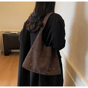 Close-up of brown hollow-out leather tote bag featuring geometric laser-cut textures