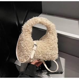 Detail of cream plush tote bag featuring fluffy fleece texture and leather strap buckle