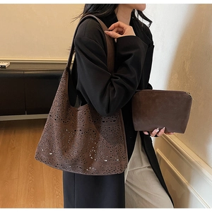 Detail of laser-cut hollow tote bag and matching clutch in dark brown faux suede
