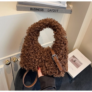 Close-up of the soft brown teddy plush texture and faux leather strap on the handbag