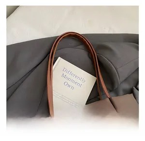 Detail of slim handles on caramel brown leather tote bag with interior view
