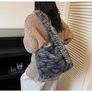Close-up of grey tiger stripe faux fur tote bag texture with plush animal print fabric