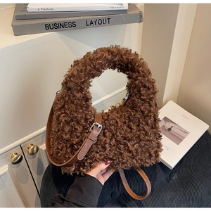 Close-up of fluffy brown teddy fleece handbag with leather strap and metal buckle detail