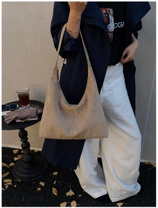 Nahaufnahme der großen Khaki-Wildleder-Hobo-Tasche kombiniert mit einem herbstlichen Trenchcoat