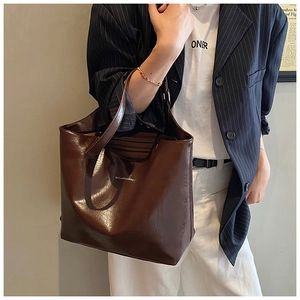 Detail view of a vintage brown large capacity tote bag worn over the shoulder for daily use