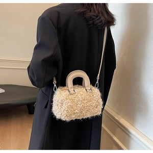 Beige faux shearling crossbody bag with leather strap shown on a model for scale