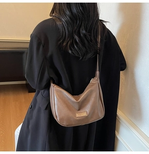 Brown soft leather crescent bag shown on a model in a black blazer for a chic look