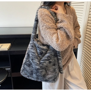 Detail of soft grey and black striped faux fur tote bag showing plush hairy texture